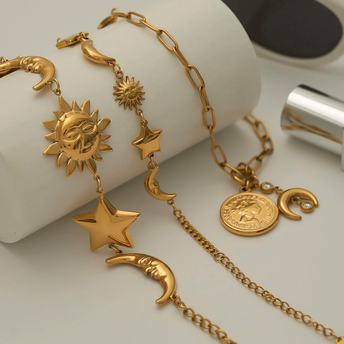 Gold celestial motif bracelet featuring sun, moon, and star charms with elegant chain links