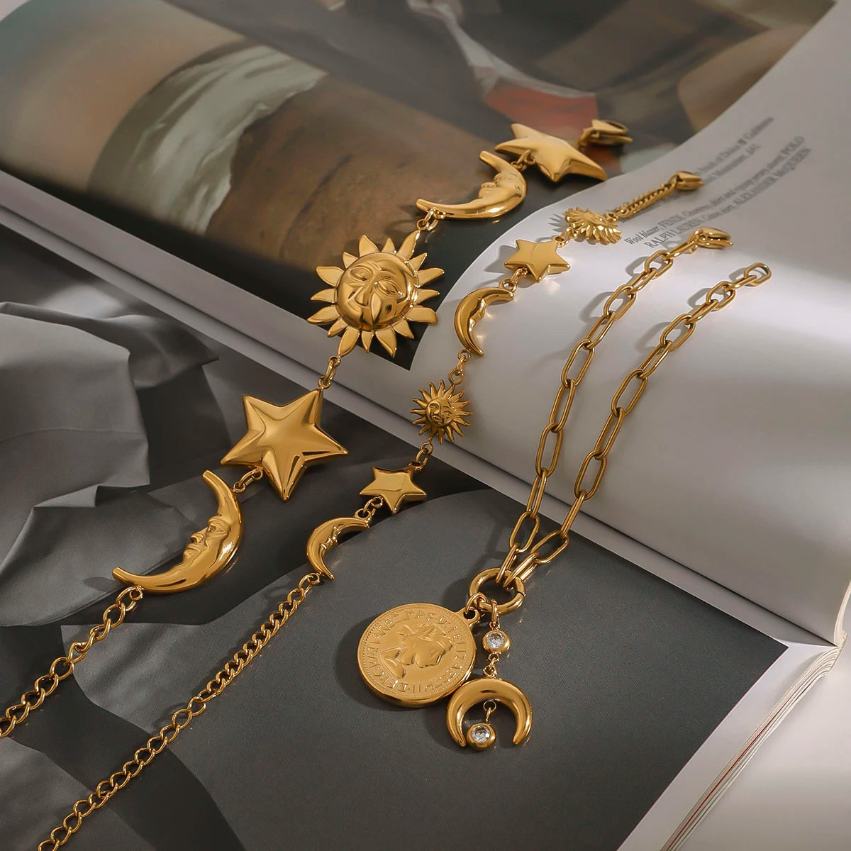 Gold celestial motif bracelet featuring sun, moon, star charms and coin pendant on chain
