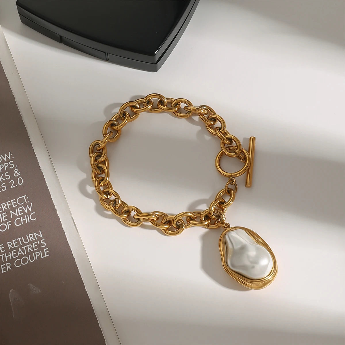Gold stacked chain bracelet with toggle clasp and large irregular white pearl charm