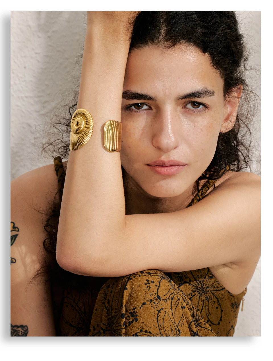 Gold waterproof open bangle with textured design worn on woman's arm